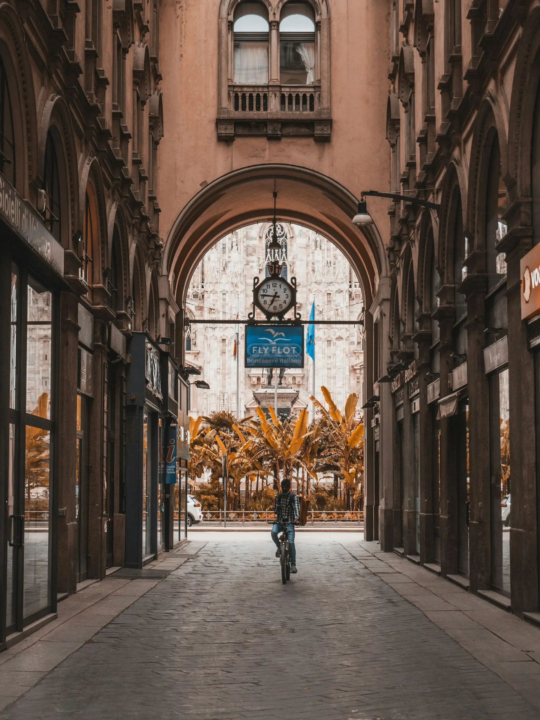 Passant à vélo sous une arche d'immeuble à Milan